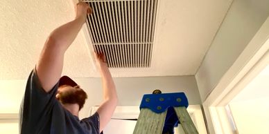 AC technician changing out an hvac filter in a customers home