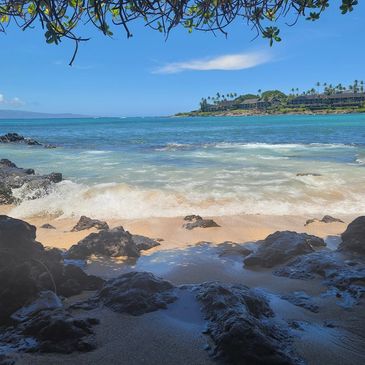Beach view with waves and rocks under a clear blue sky. In Hawaii is a Terrapin Station Dive site. F