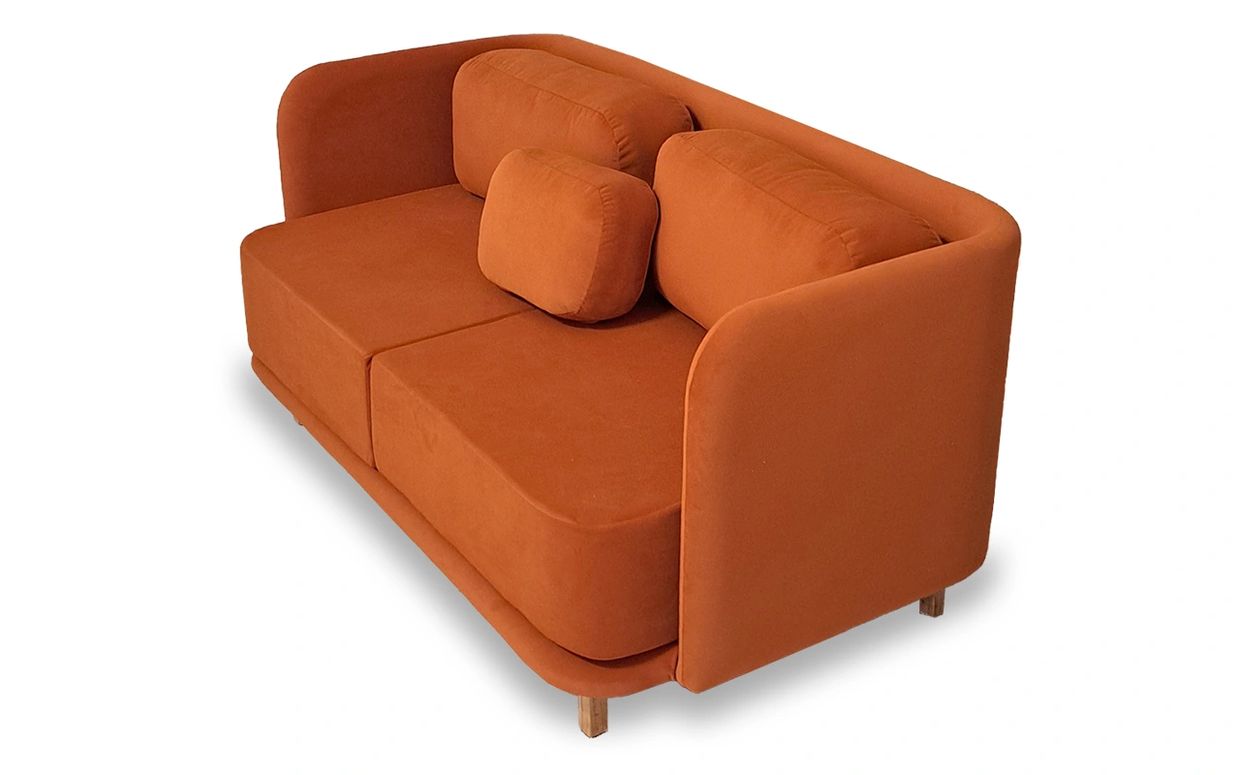 Modern burnt orange fabric sofa with wooden legs and plush cushions.