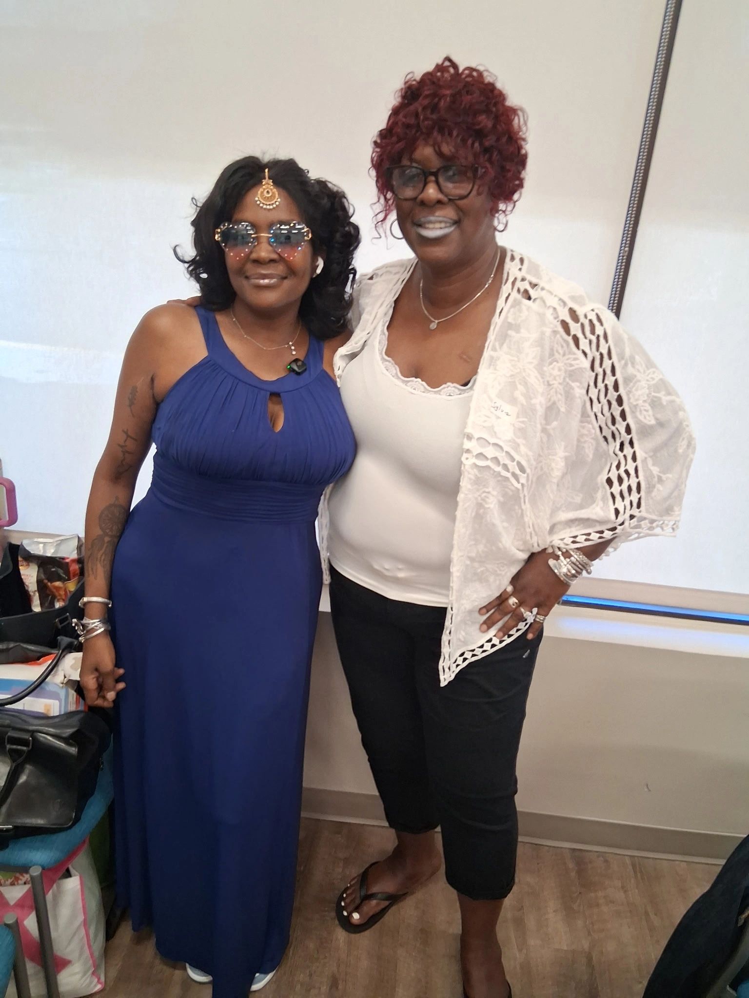 Two women posing and smiling indoors.