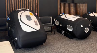 Two black futuristic pods in a room.