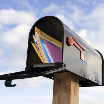 Mailbox full of colorful envelopes.