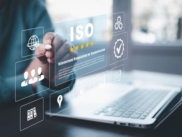 Hand interacting with a digital display showing ISO certification.