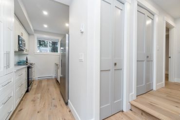Bright, modern kitchen with light wood floors and white cabinetry.