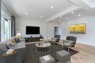 Modern living room with gray furniture and yellow accent pillows.