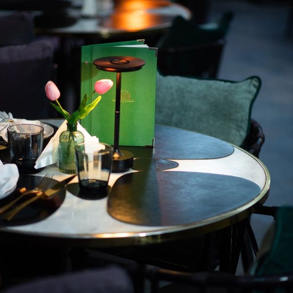Elegant dining table with tulip decoration and modern lighting in a cozy setting.