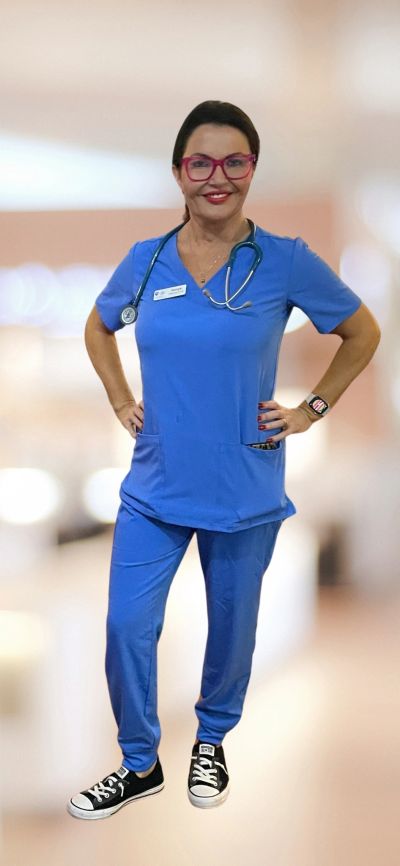 Smiling female nurse in blue scrubs and stethoscope.