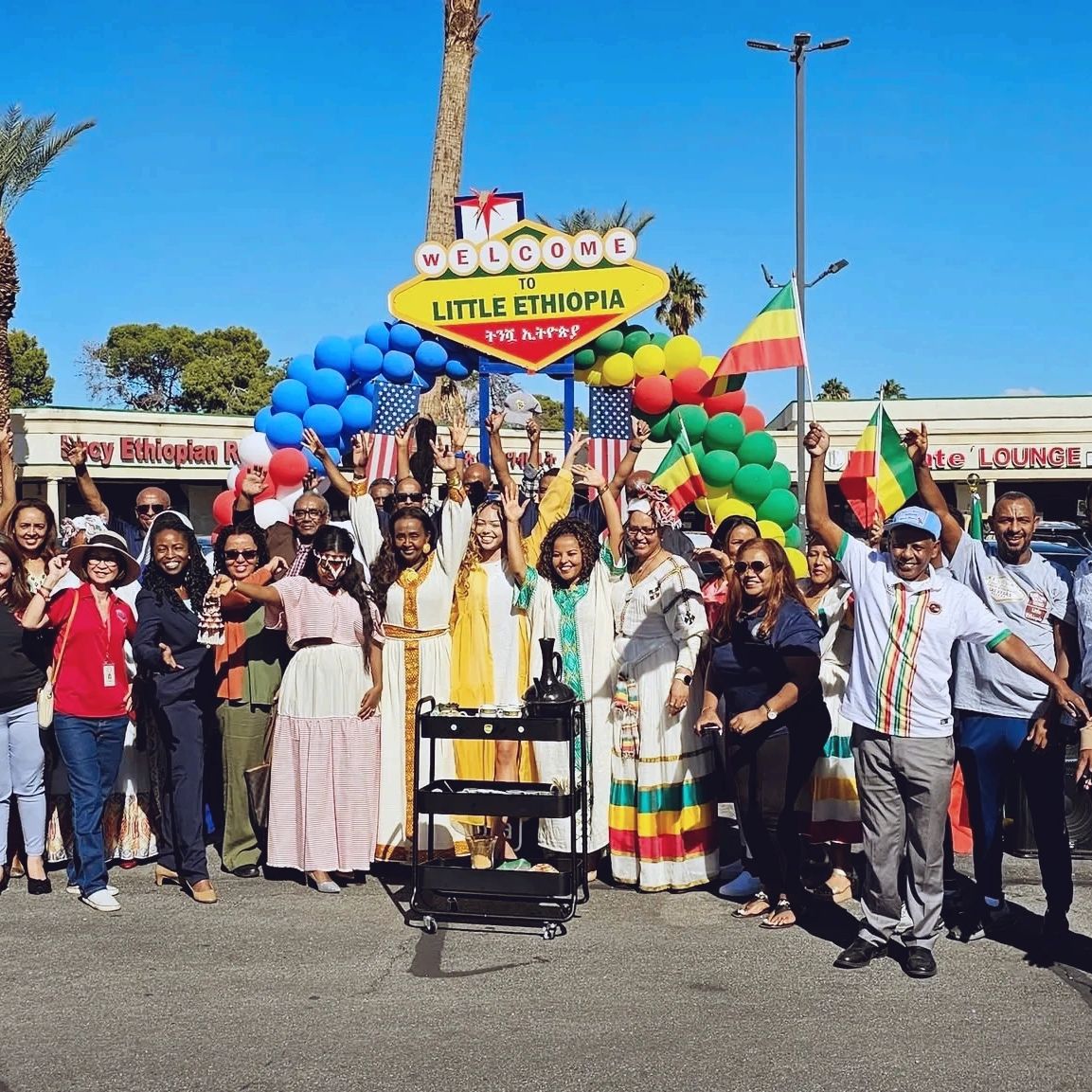 Group celebrating Little Ethiopia with flags and traditional attire.