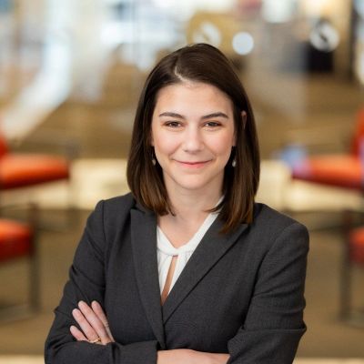 Professional woman in business attire smiling confidently.