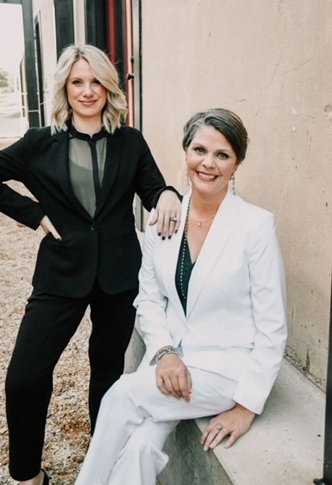 Two female attorneys. One is sitting and one is standing