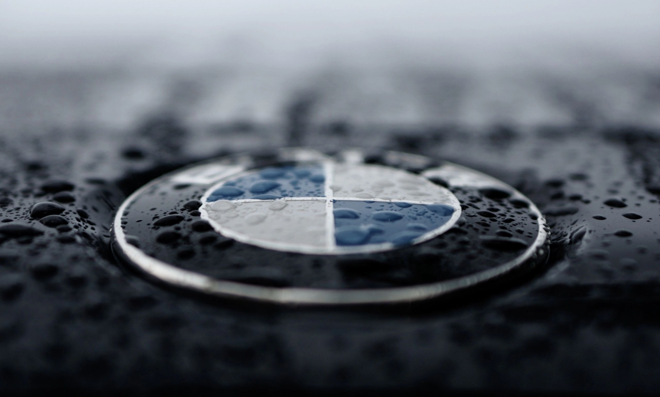 BMW logo on a car with raindrops