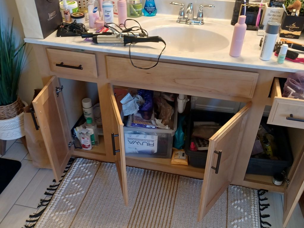 cluttered bathroom before organization with overcrowded cabinets