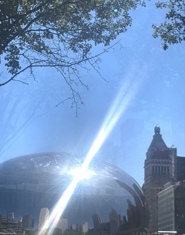 Sunlight reflecting off a shiny building dome in a city.