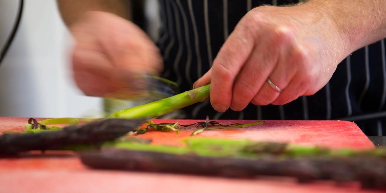 chef hands peeling asparagus