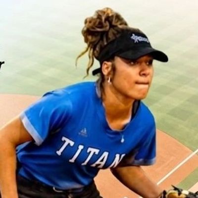 Softball player in a Titan jersey pitching.