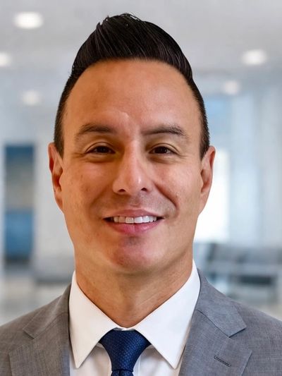 Professional man in suit smiling in an office setting.