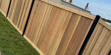 New wooden privacy fence with green grass beside it.