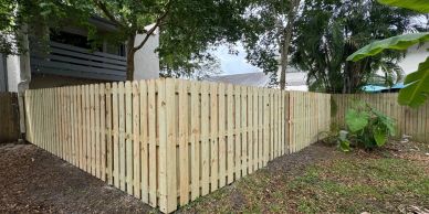 Newly installed wooden fence surrounding a backyard.