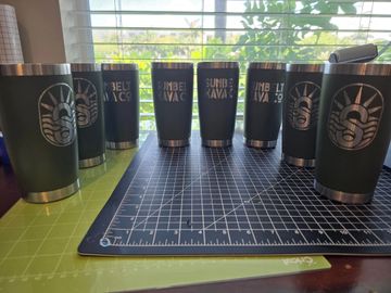 company laser etched tumblers showcased in a half circle on a table