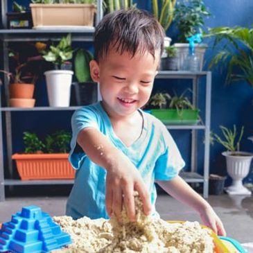 child playing in a sand table working on sensory integration