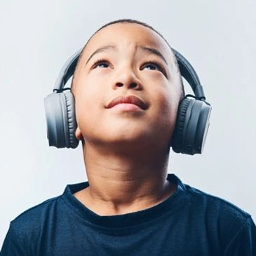 Child wearing headphones looking up to the ceiling undergoing therapeutic listening