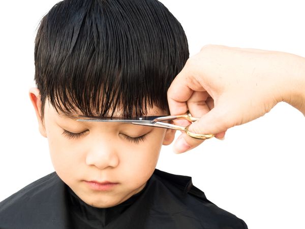 Young male child sitting completely still while receiving a haircut