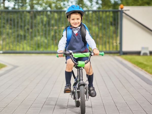 Boy sitting on his bike with helmet and backpack