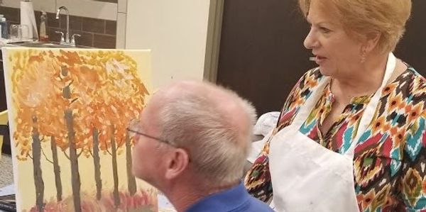 an instructor guiding a student painter