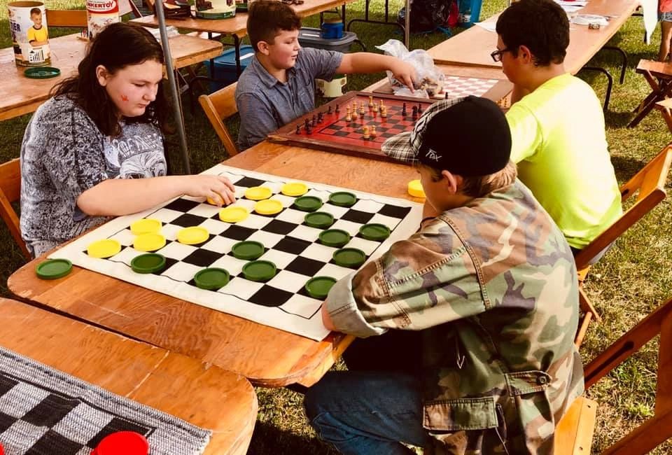 kids playing checkers at a local festival