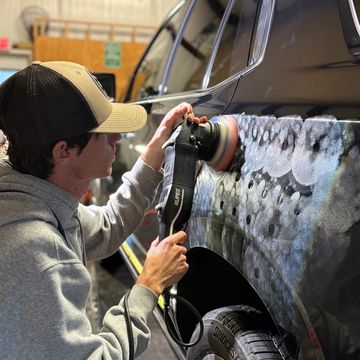 Guy using polisher on black car