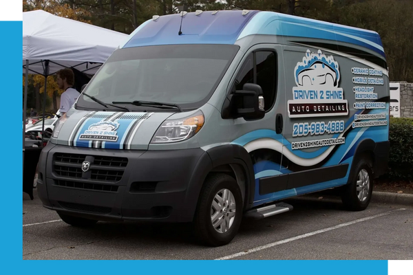 A blue and black auto detailing van with company branding and contact information.