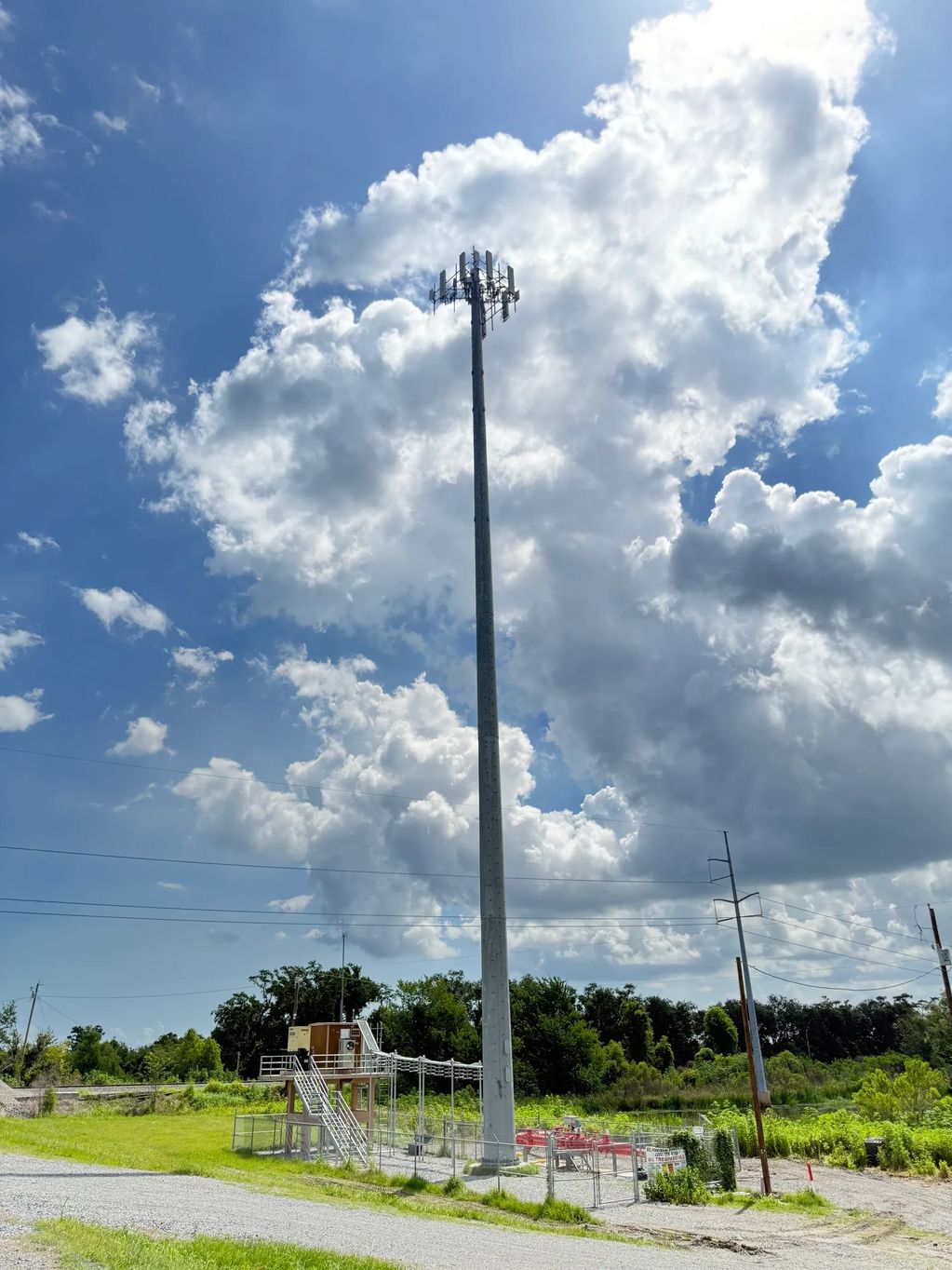 A tall communication tower against a partly cloudy sky.