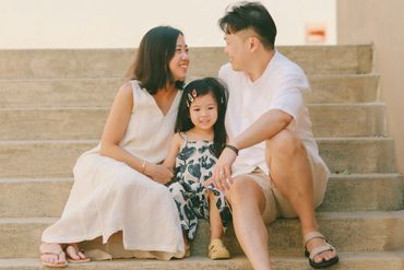 A family and their child sitting on steps