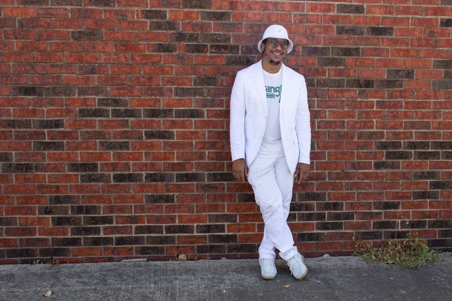 BENCJONES leaning on a brick wall