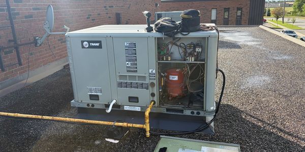 Rooftop HVAC unit with open panel revealing internal components.