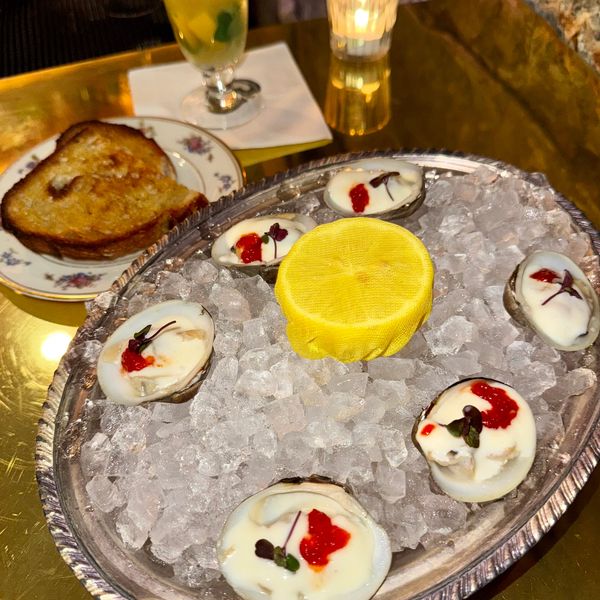 Oysters on ice with a lemon centerpiece and toasted bread on the side.