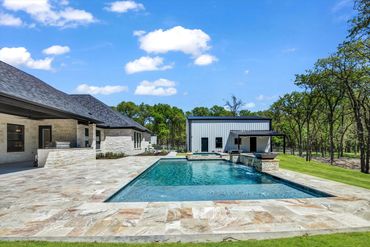 Modern house with a large swimming pool and a clear blue sky.