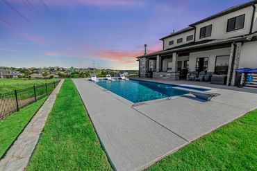 Modern house with a swimming pool and sunset sky.