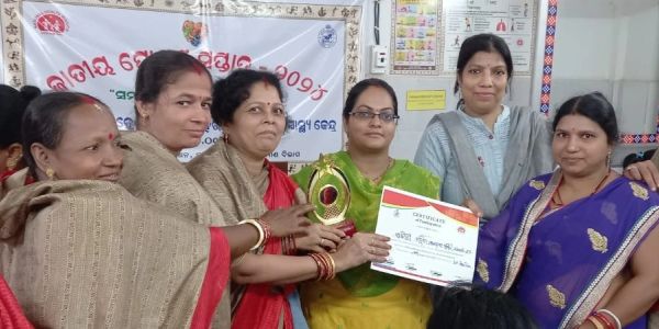 A group of women receiving an award and certificate together.