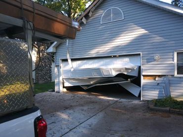Outside/exterior view of damaged garage door.