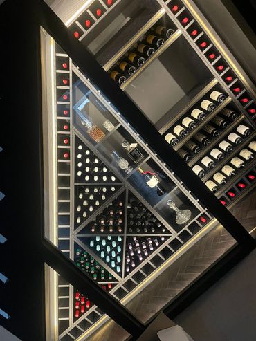 Fully stocked wine rack using space under staircase