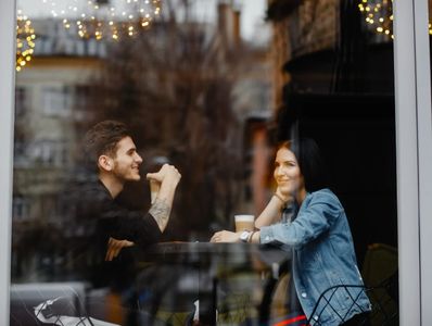 man and woman having coffee while a private investigator takes photos for an infidelity investigatio