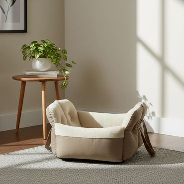 Ein Katzenkörbchen steht in einem Wohnzimmer.