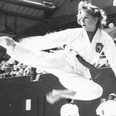 Adult karate student doing flying taekwondo kick.