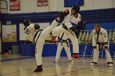 Adult Taekwondo students in a martial arts sparring match.