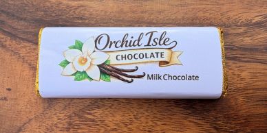 Orchid Isle Milk Chocolate bar with vanilla flower and pods on wrapper.