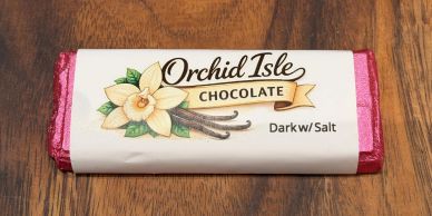 Orchid Isle Dark Chocolate with Salt bar on wooden surface.