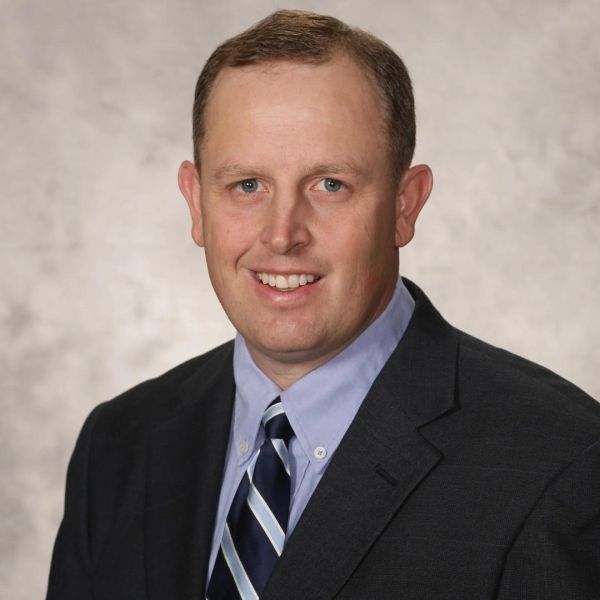 Professional headshot of a man in a suit and tie.