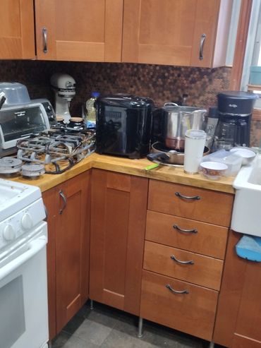 Cozy kitchen corner with wooden cabinets and various appliances on the countertop.