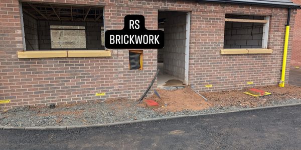 New brickwork on a house under construction with window and door openings.